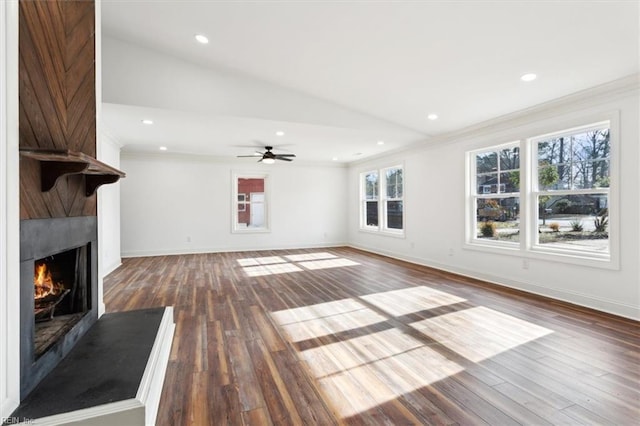 unfurnished living room featuring a large fireplace, baseboards, ornamental molding, wood finished floors, and recessed lighting