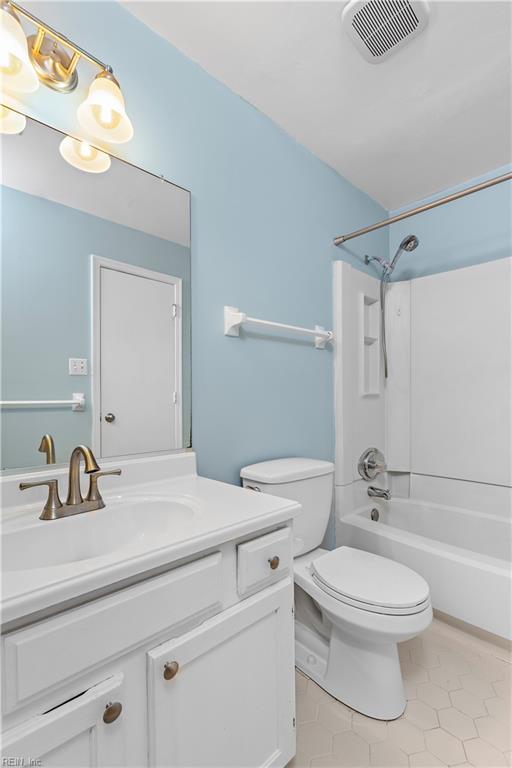 bathroom featuring shower / tub combination, toilet, tile patterned flooring, vanity, and visible vents