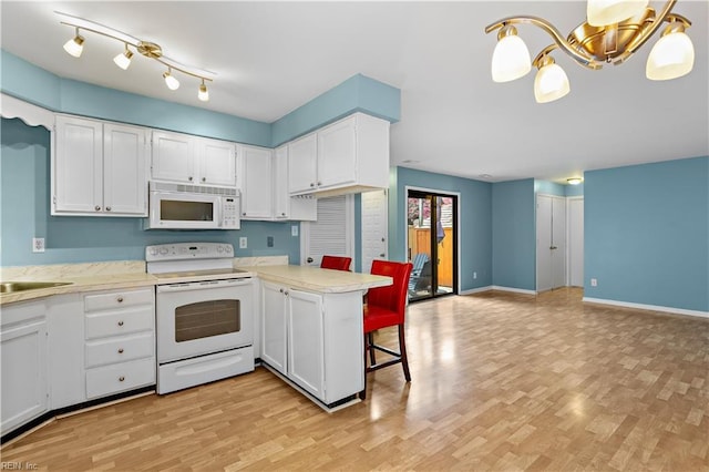 kitchen with light countertops, white appliances, light wood-style floors, and white cabinets