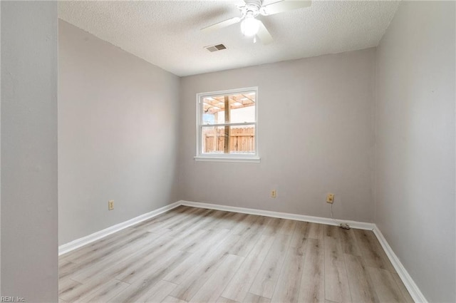 empty room featuring light wood-type flooring, ceiling fan, a textured ceiling, and baseboards