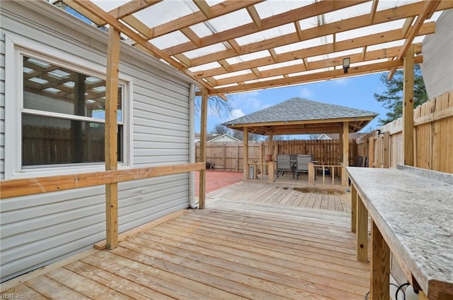 deck with outdoor dining space and a fenced backyard