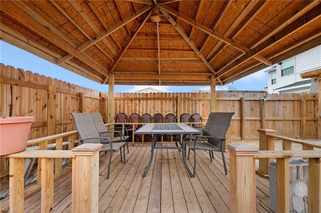 wooden deck featuring a gazebo, fence, and outdoor dining space