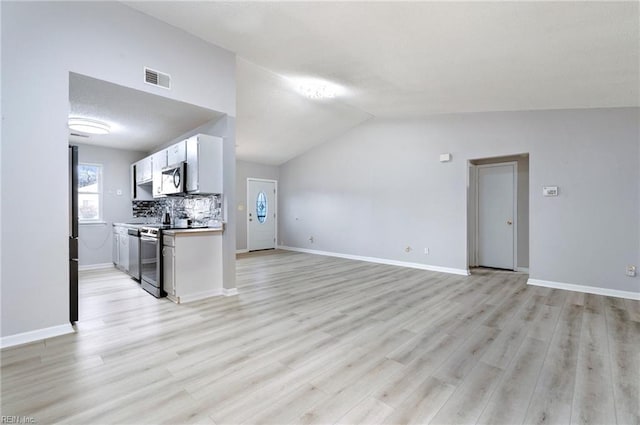 living area featuring vaulted ceiling, light wood-type flooring, visible vents, and baseboards