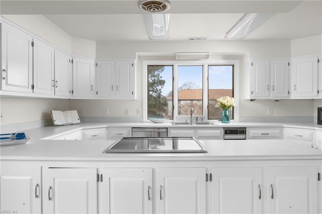 kitchen featuring light countertops, white cabinets, and a sink