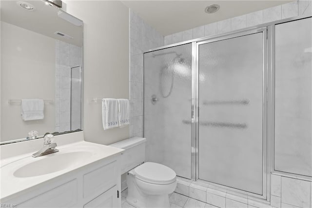 bathroom featuring toilet, vanity, a shower stall, and visible vents