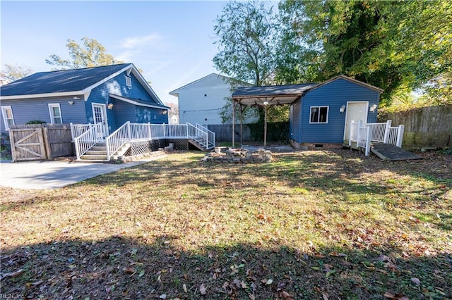 back of property with a patio, fence, a lawn, crawl space, and a wooden deck