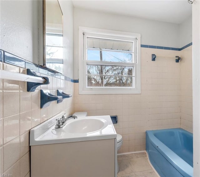 full bath with toilet, tile walls, and vanity