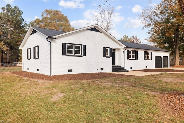 view of front of home featuring a garage, brick siding, fence, crawl space, and a front lawn