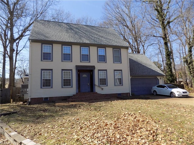 colonial inspired home with a garage, crawl space, roof with shingles, and driveway