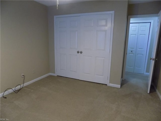 unfurnished bedroom featuring carpet floors, baseboards, and a closet