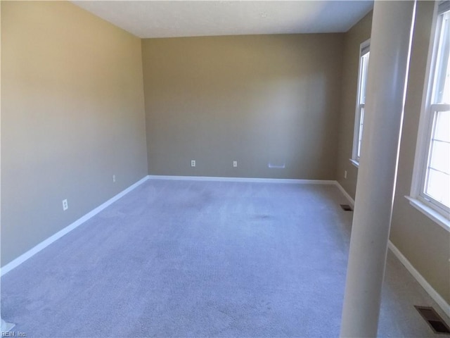 unfurnished room with carpet, baseboards, and visible vents