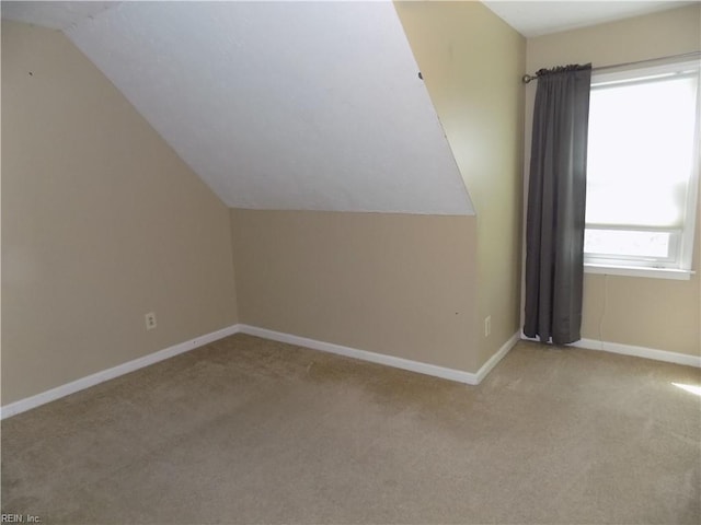 additional living space with vaulted ceiling, carpet, and baseboards