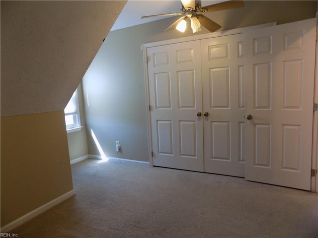 bonus room with carpet, a ceiling fan, vaulted ceiling, a textured ceiling, and baseboards