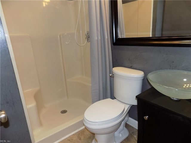 bathroom featuring toilet, a shower stall, and vanity