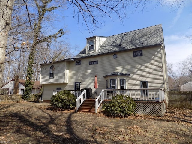 rear view of property featuring fence and a wooden deck