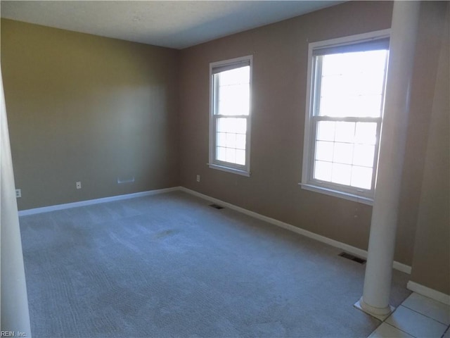 carpeted empty room with baseboards and visible vents