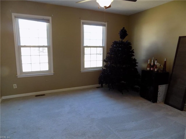 miscellaneous room with carpet floors, ceiling fan, visible vents, and baseboards