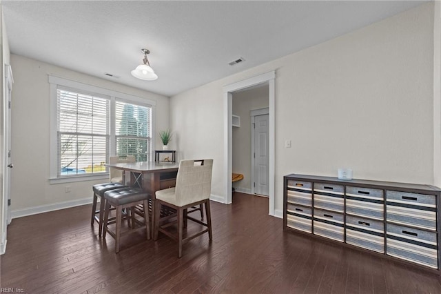 dining space featuring visible vents, dark wood finished floors, and baseboards