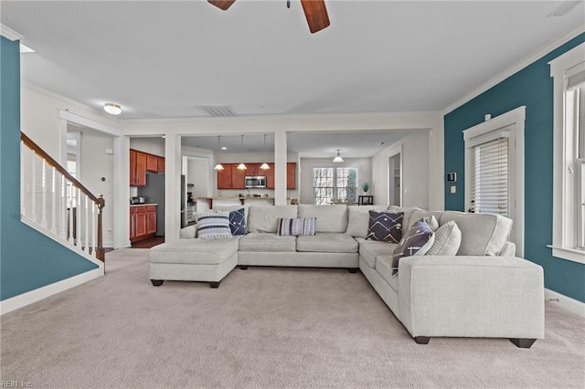 living room featuring light carpet, baseboards, stairway, and ornamental molding