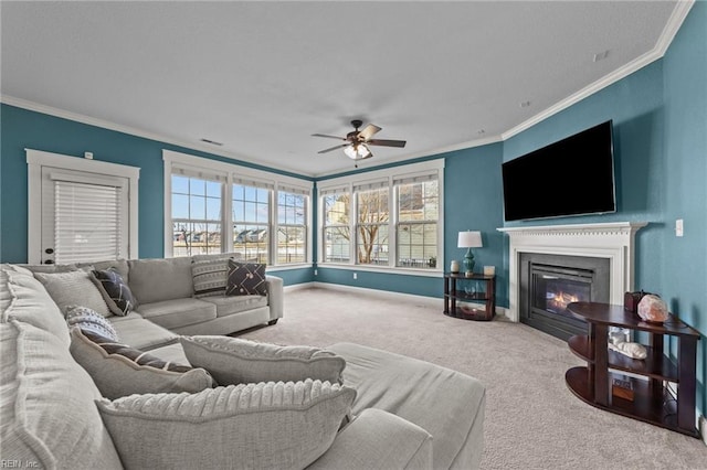 living room featuring visible vents, baseboards, a glass covered fireplace, carpet, and crown molding