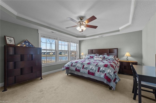 carpeted bedroom featuring a tray ceiling, crown molding, a ceiling fan, a textured ceiling, and baseboards