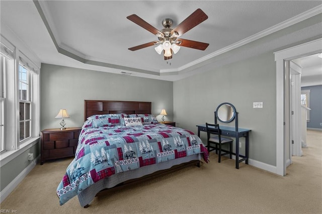 carpeted bedroom with ornamental molding, ceiling fan, a tray ceiling, and baseboards