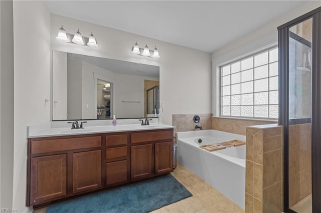 bathroom featuring double vanity, a garden tub, a sink, and a stall shower