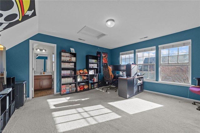 home office with visible vents, carpet floors, lofted ceiling, and attic access