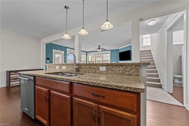 kitchen with stone countertops, dark wood-style flooring, decorative light fixtures, and a sink