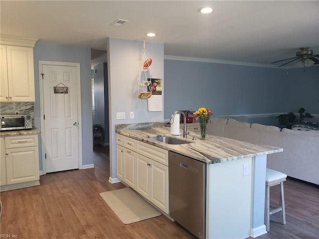 kitchen featuring a peninsula, wood finished floors, a sink, visible vents, and dishwasher