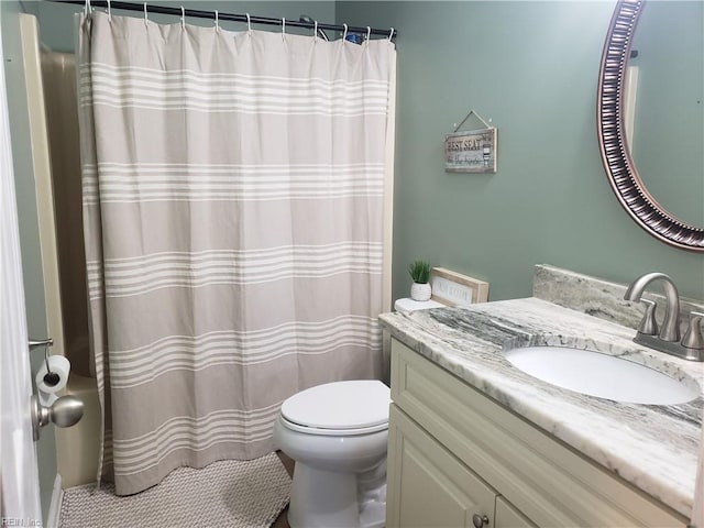 full bath featuring toilet, curtained shower, and vanity