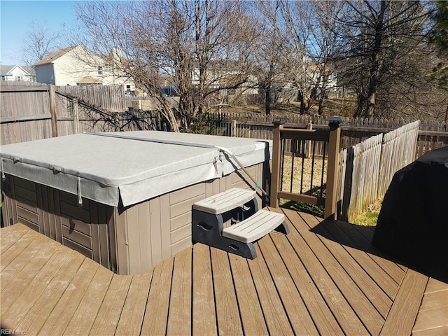 wooden deck with a fenced backyard and a hot tub