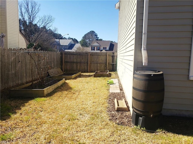 view of yard featuring fence and a vegetable garden