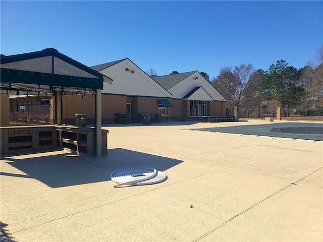 community pool with a patio and fence