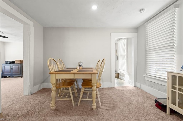 carpeted dining space featuring baseboards