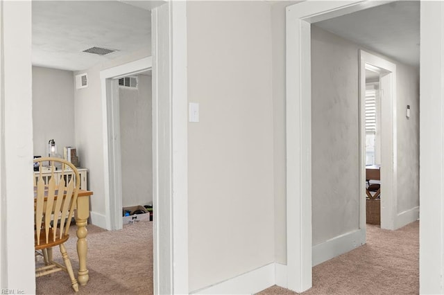 corridor featuring carpet, visible vents, and baseboards