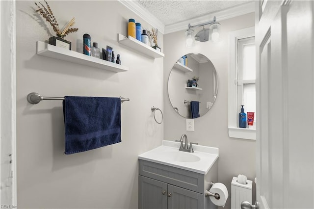 bathroom featuring a textured ceiling, ornamental molding, and vanity