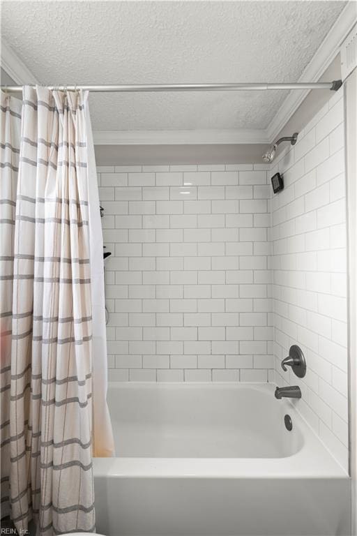 bathroom featuring crown molding, shower / bath combo, and a textured ceiling