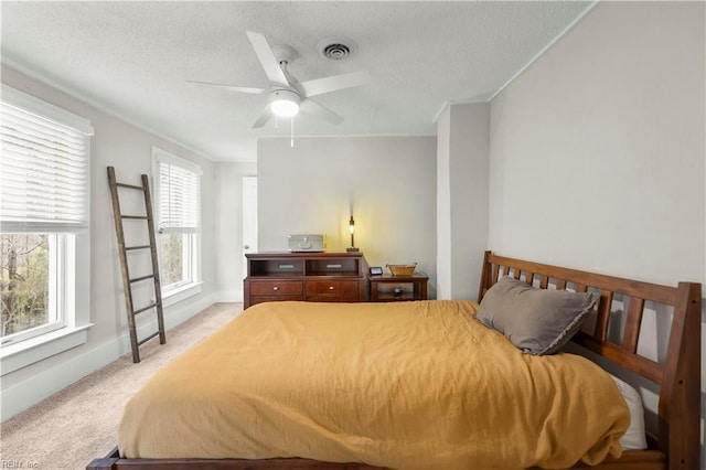 bedroom featuring baseboards, visible vents, a textured ceiling, and light colored carpet