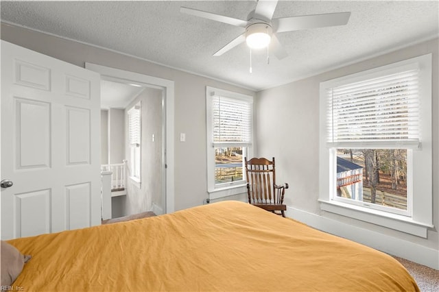 bedroom featuring a textured ceiling, ceiling fan, and baseboards