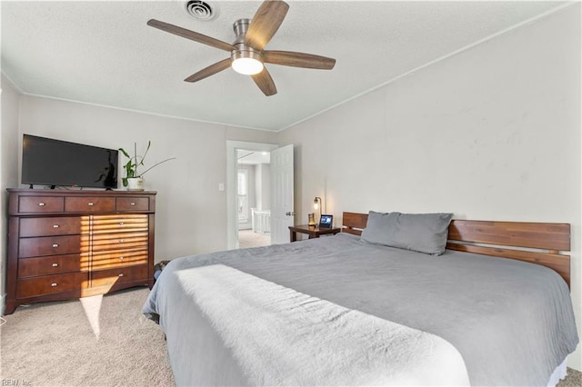 bedroom with a ceiling fan, carpet, visible vents, and a textured ceiling