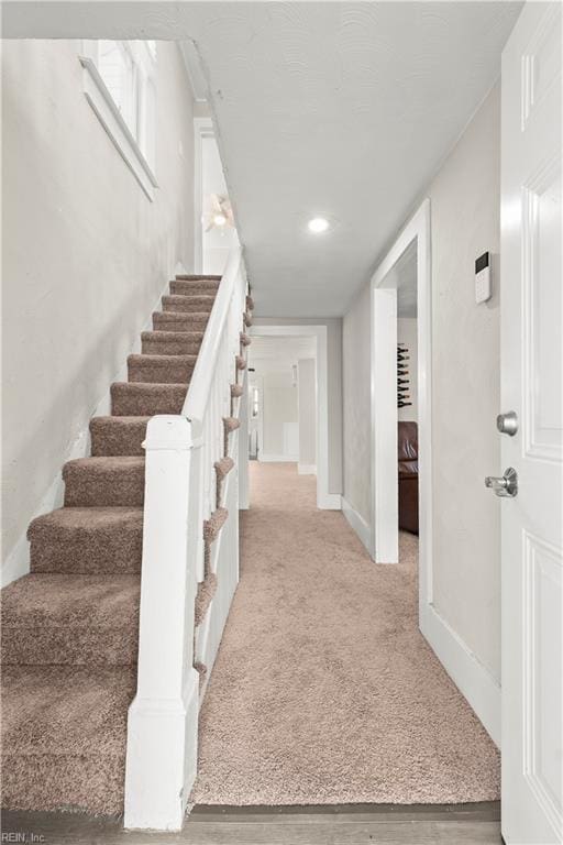 stairs featuring carpet and baseboards