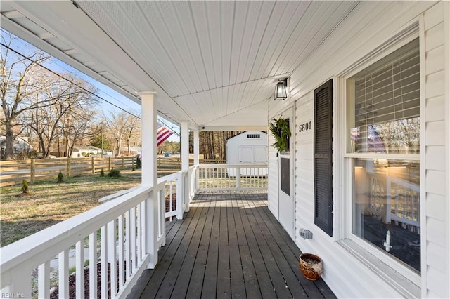 deck featuring covered porch and fence