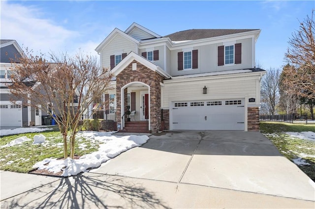 traditional home with driveway, stone siding, an attached garage, and fence