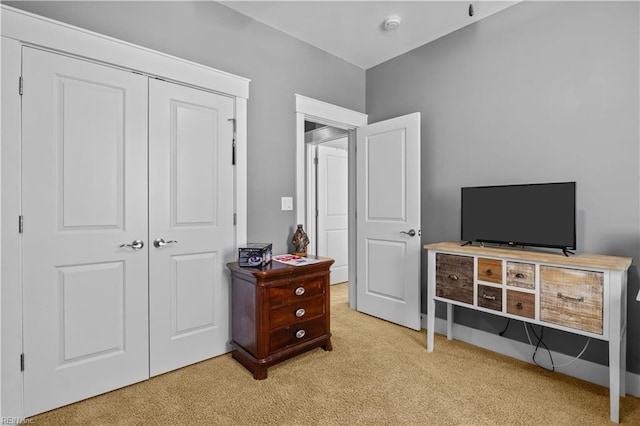 bedroom featuring a closet and light colored carpet