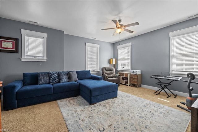 carpeted living room with ceiling fan, visible vents, and baseboards