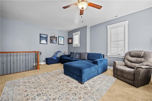 carpeted living room with a healthy amount of sunlight, visible vents, and baseboards