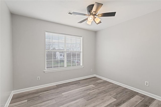 unfurnished room with a ceiling fan, baseboards, and wood finished floors