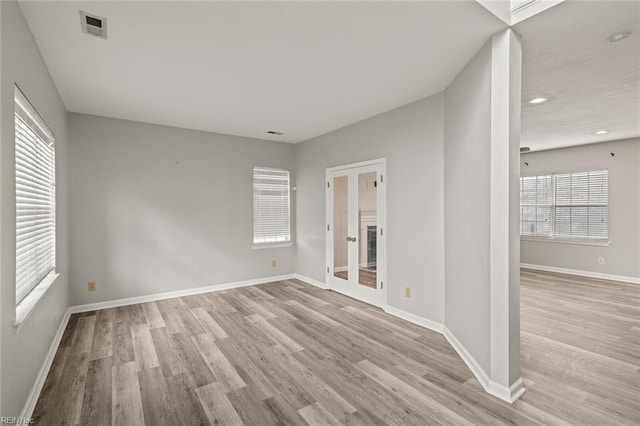 unfurnished room with recessed lighting, wood finished floors, visible vents, baseboards, and french doors