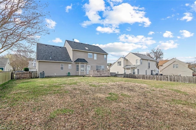 back of house with a residential view, central AC, a lawn, and a fenced backyard